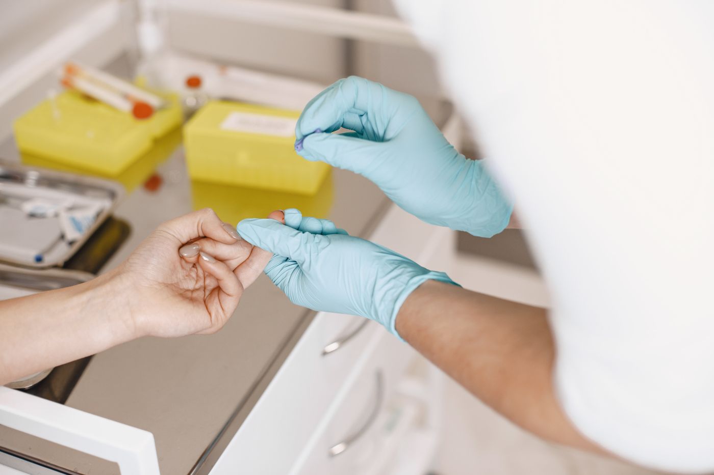Healthcare worker taking a finger-prick blood sample